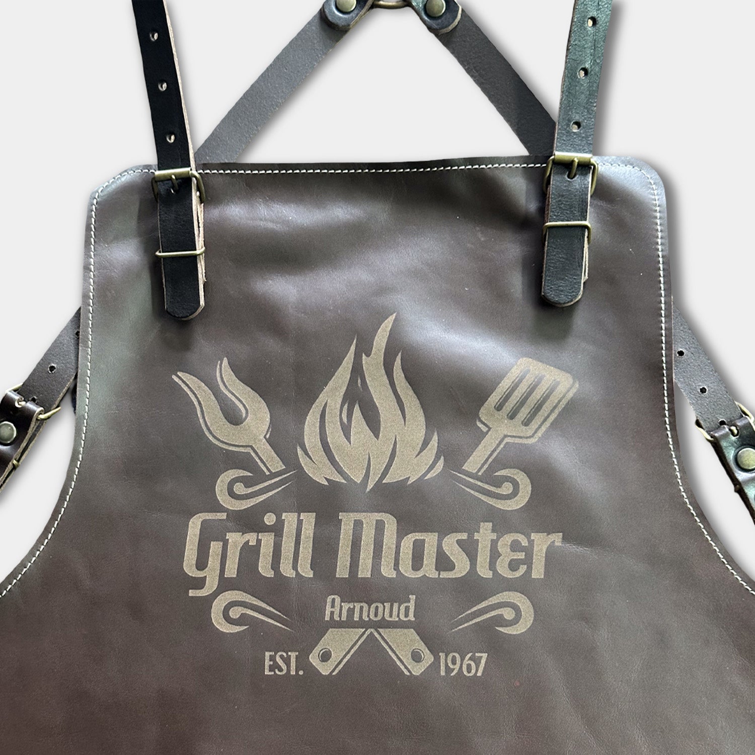 Brown leather apron with 'Grill Master' laser engraved logo close up view