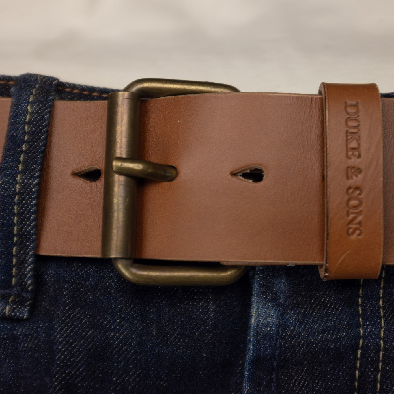 Duke and Sons 2-inch cognac leather jeans belt with old bronze buckle wear on jeans hero image