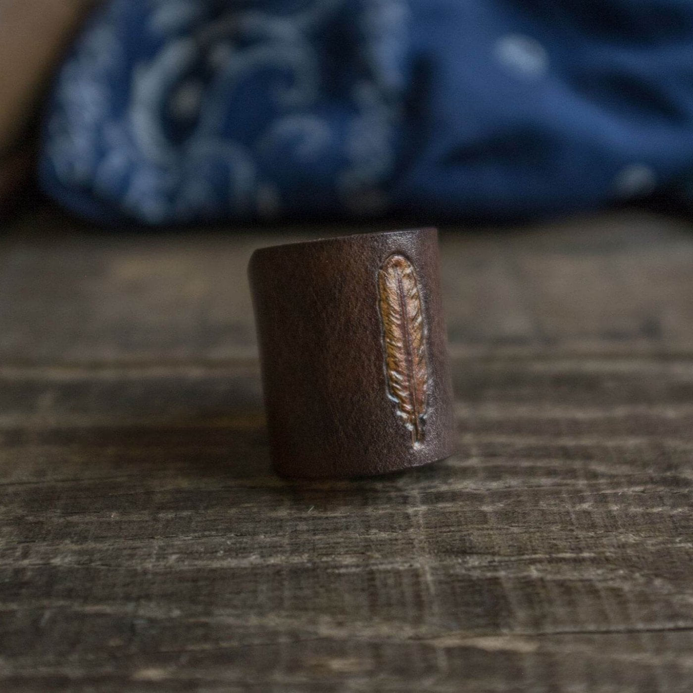 Woggle, bandana / neckerchief slide made from leather with a feather image stamp close up
