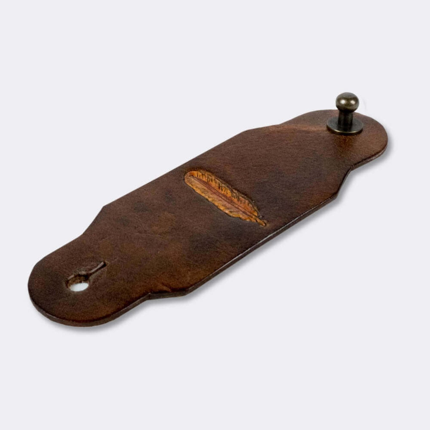 Woggle, bandana / neckerchief slide made from leather with a feather image stamp, slanted view