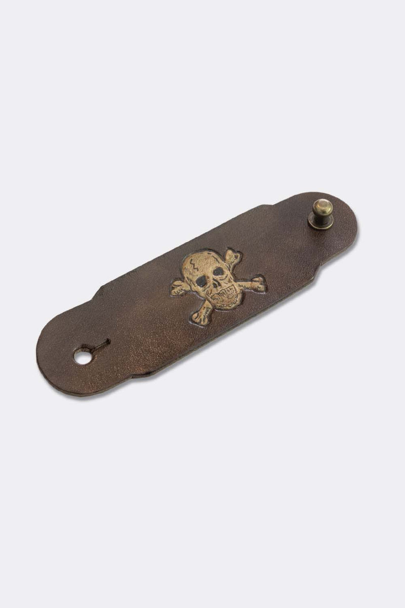 Woggle, bandana / neckerchief slide in brown leather with a skull image stamp, slanted view