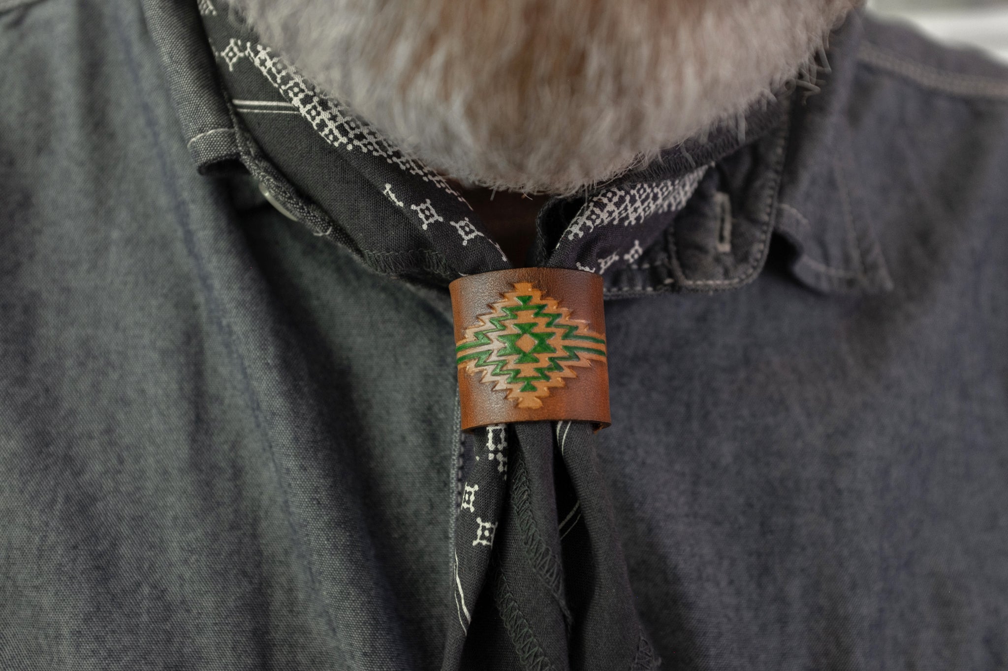 Cognac leather bandana woggle around a blue bandana wear around the neck.