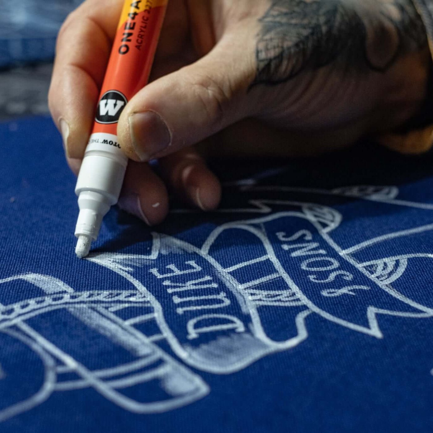 detail close-up Hand drawing the anchor image on the blue canvas tote bag