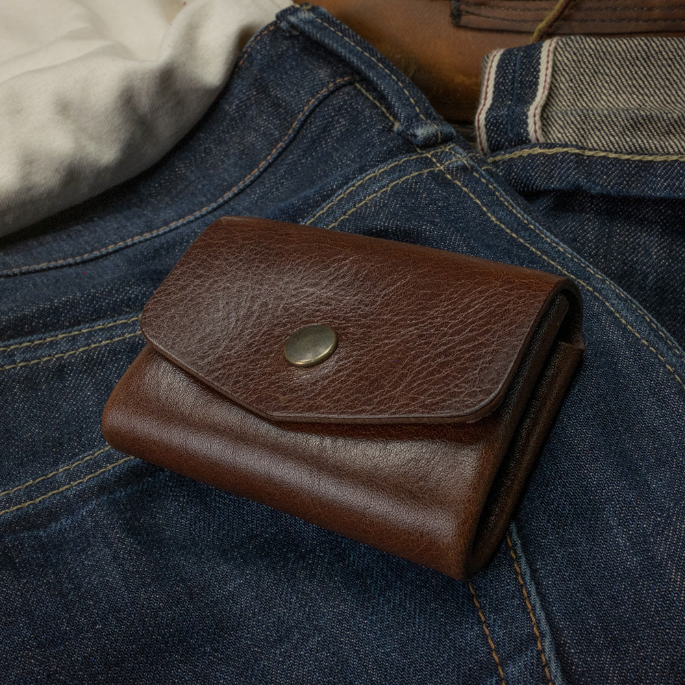 Pocket wallet dark brown top view on denim scene