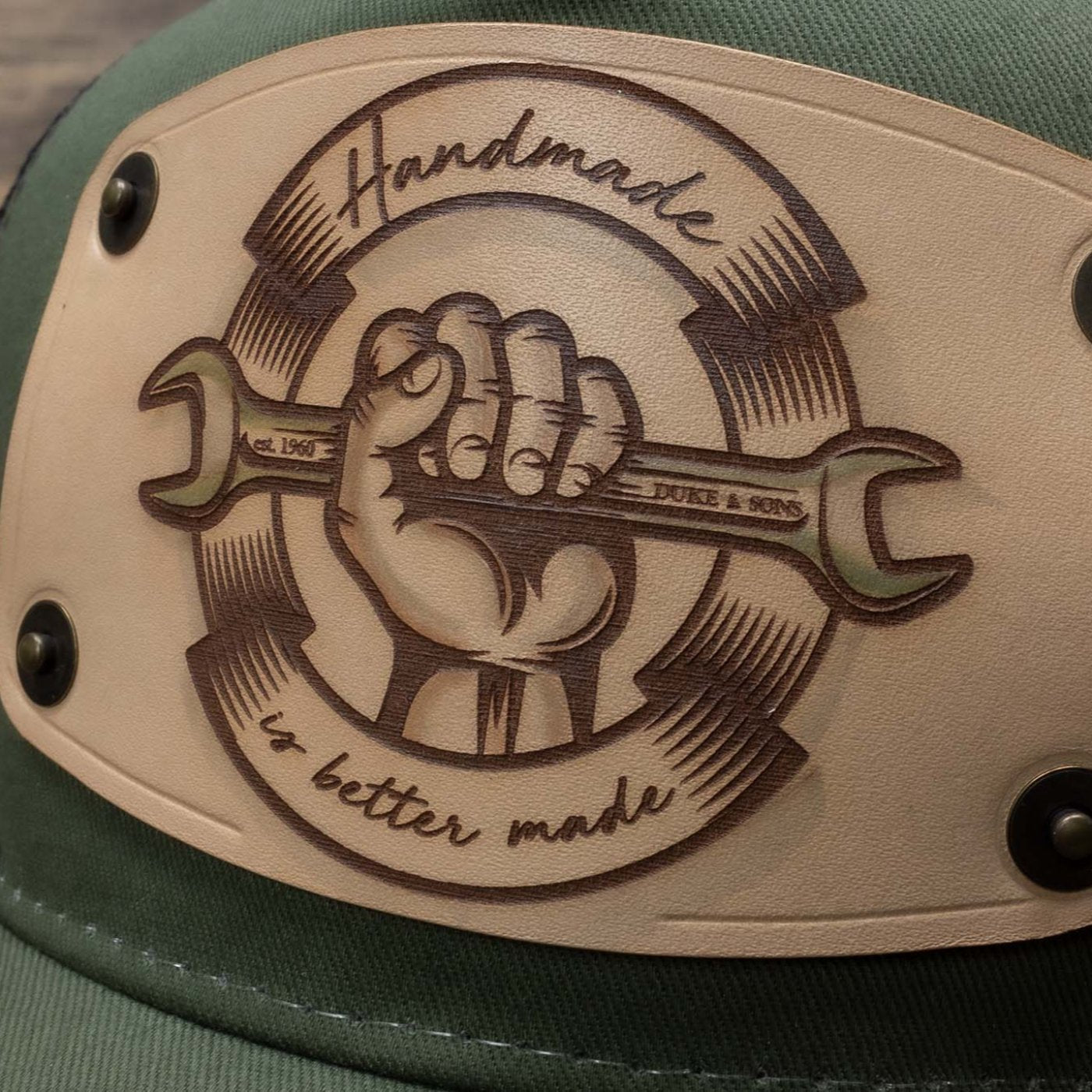 detail Green trucker cap with handmade leather patch spanner | Duke and Sons Leather