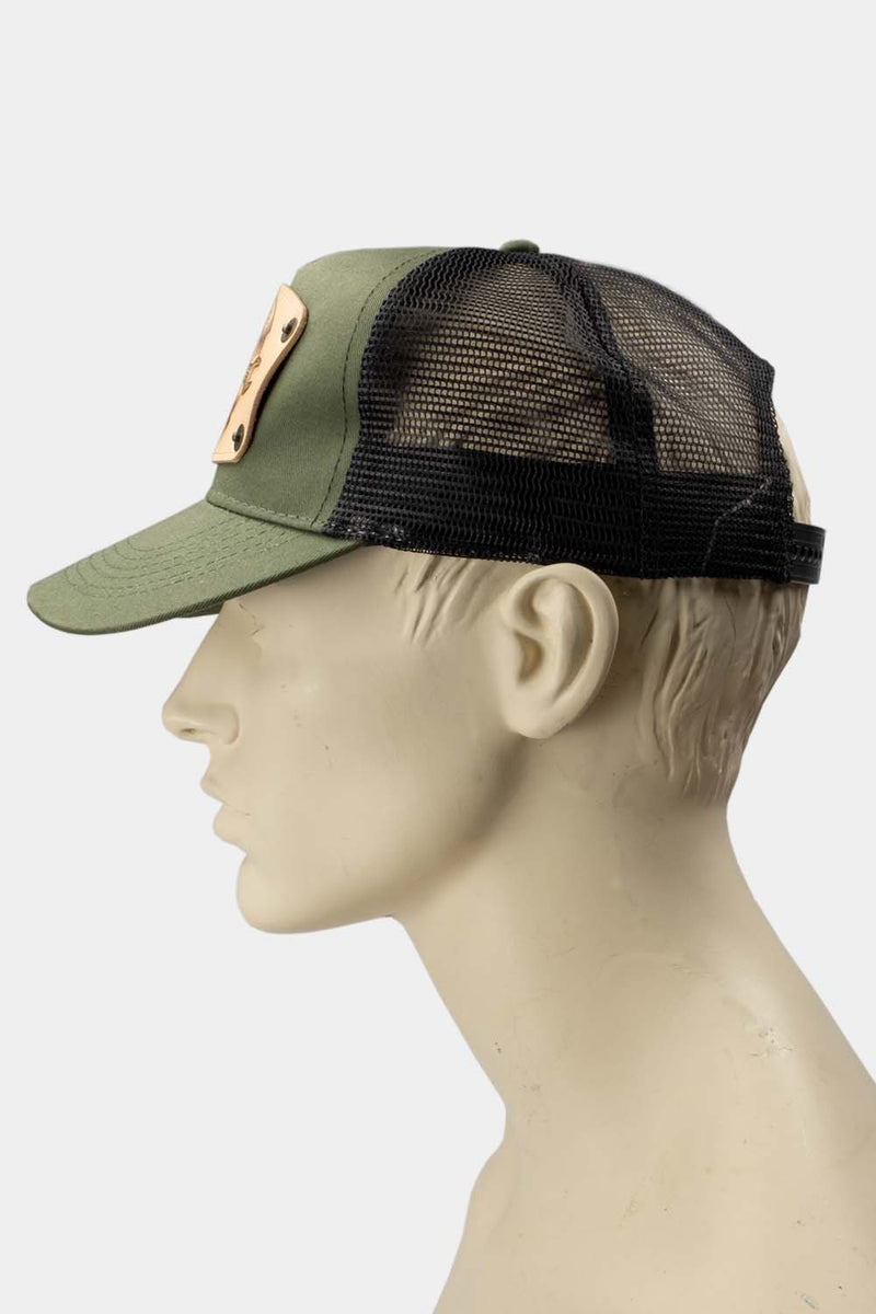 wearing green trucker cap with handmade leather patch spanner side | Duke and Sons Leather