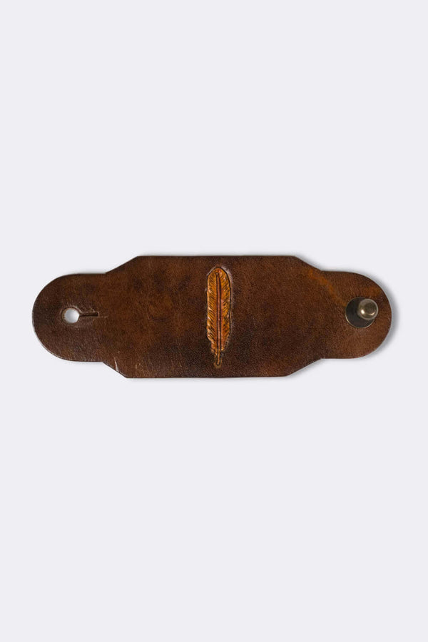Woggle, bandana / neckerchief slide made from brown leather with a feather image stamp