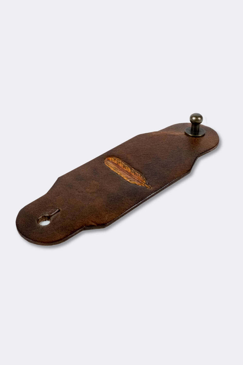Woggle, bandana / neckerchief slide made from leather with a feather image stamp, slanted view