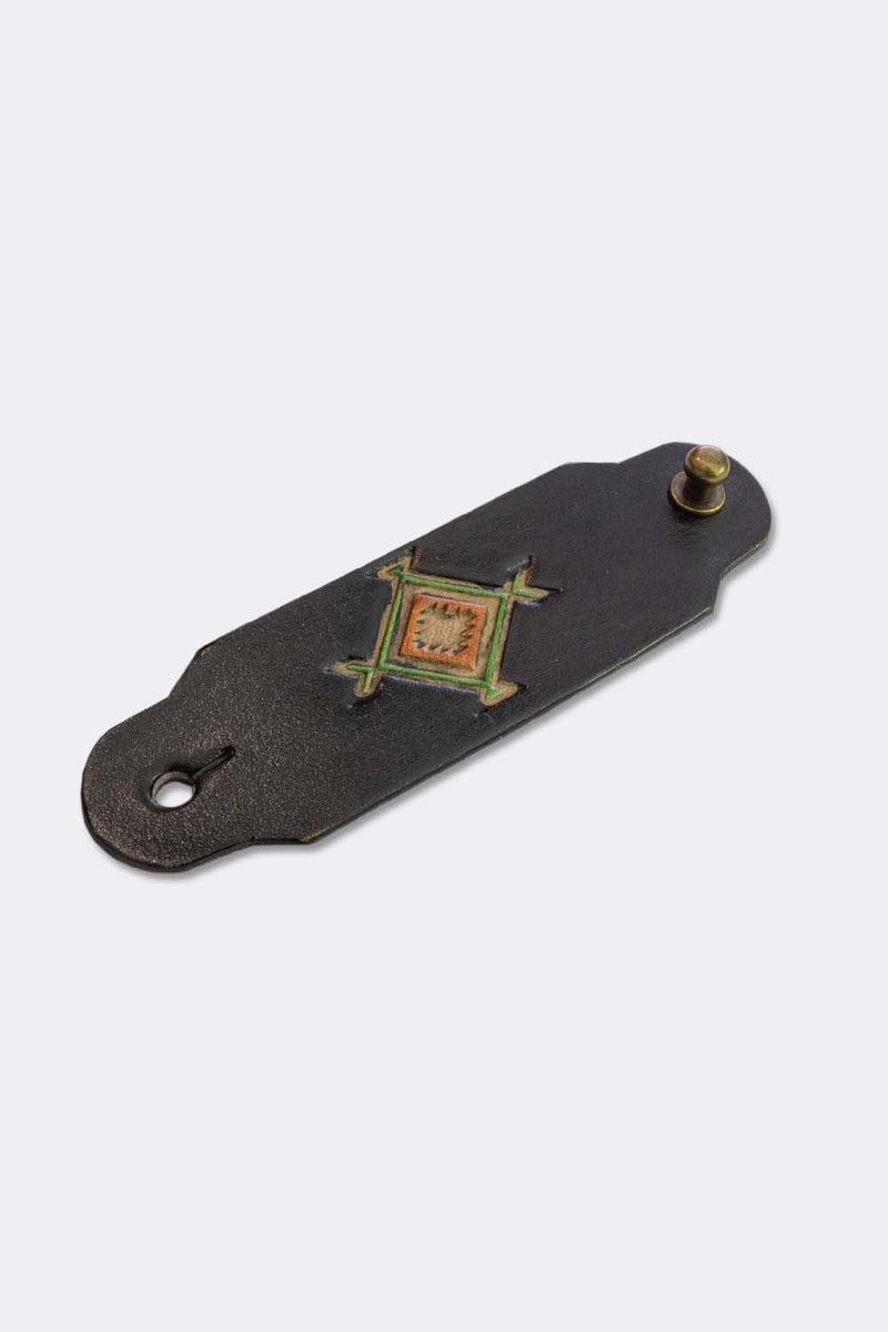 Woggle, bandana / neckerchief slide in black leather with a square native pattern stamp, slanted view