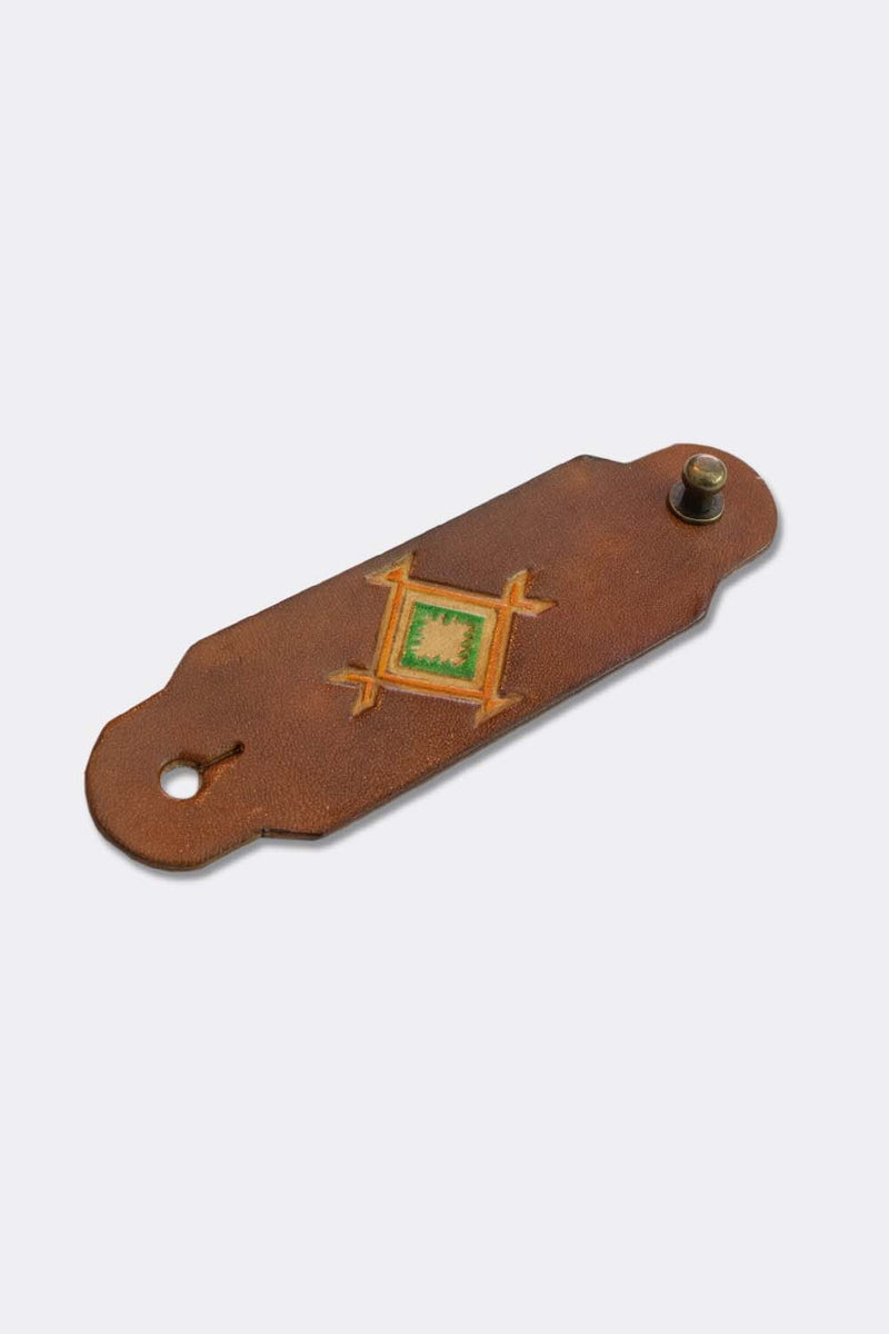 Woggle, bandana / neckerchief slide in cognac leather with a square native pattern stamp, slanted view