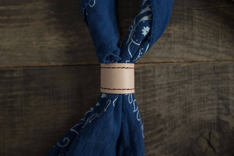 Woggle, bandana / neckerchief slide - in natural leather. Duke & Sons Leather, wearinggg around a blue bandana