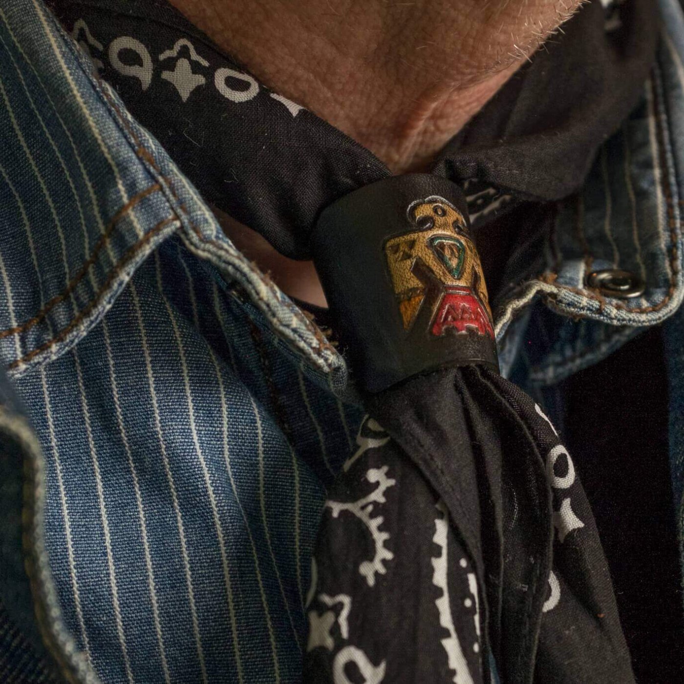 Woggle, bandana / neckerchief slide made from black leather with a native eagle symbol  image stamp, wearing  around a bandana