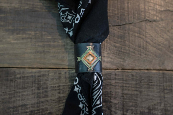 Woggle, bandana / neckerchief slide in black leather with a square native pattern stamp, around a black bandana