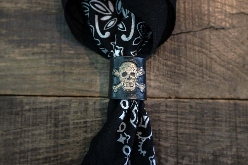 Woggle, bandana / neckerchief slide in black leather with a skull image stamp, around a black bandana
