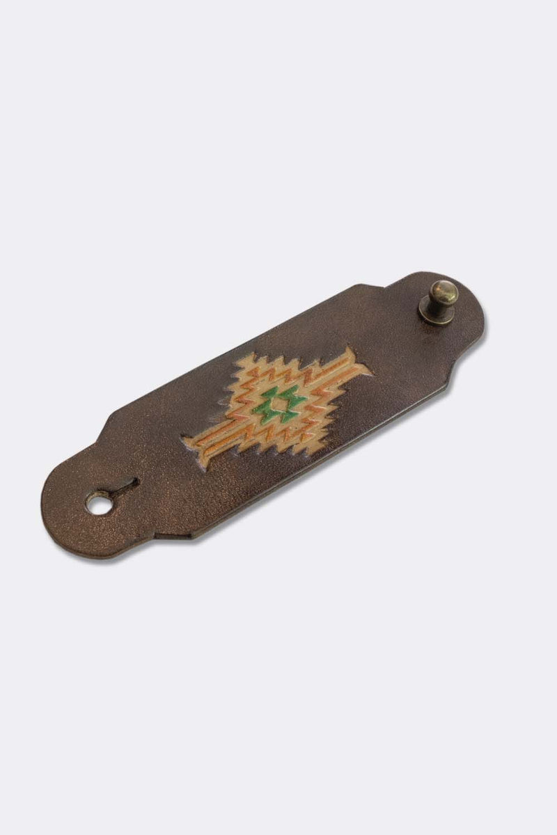 Woggle, bandana / neckerchief slide in brown leather with a rectangle native pattern stamp, slanted view