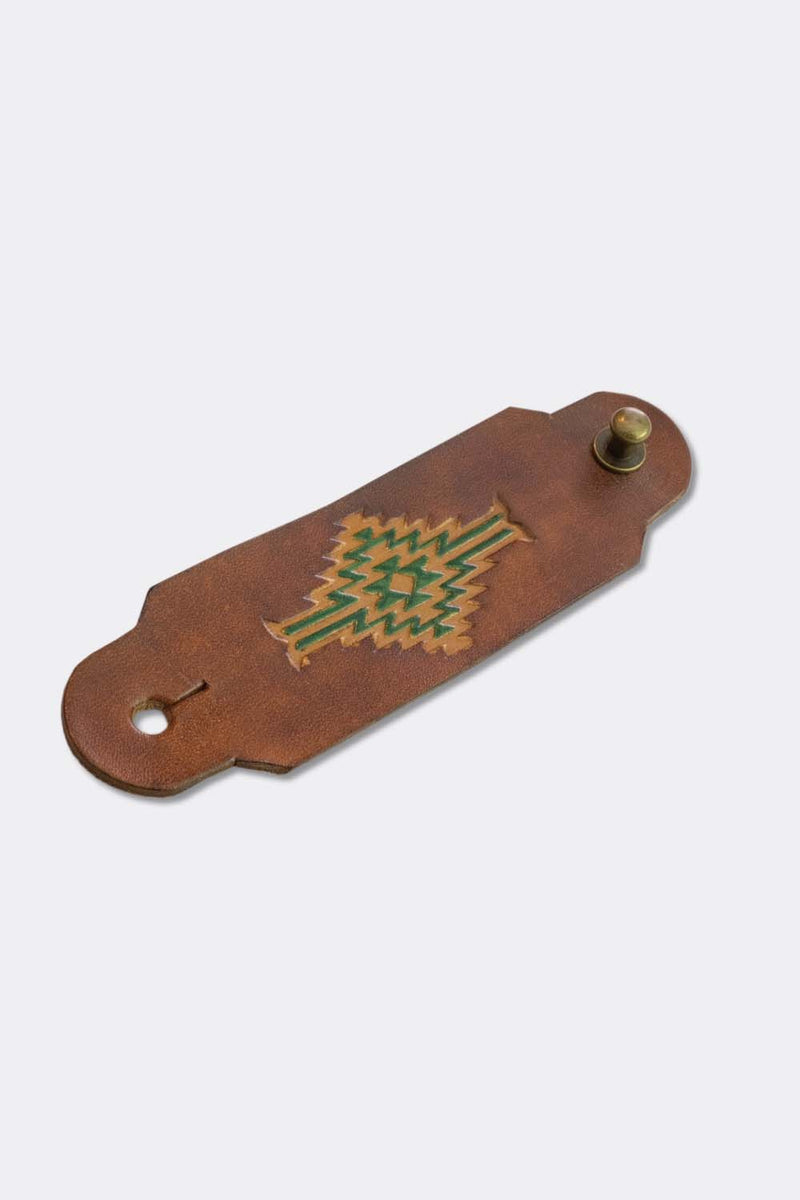 Woggle, bandana / neckerchief slide in cognac leather with a rectangle native pattern stamp, slanted view