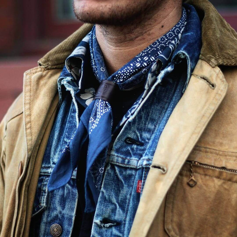 Woggle, bandana / neckerchief slide in brown leather - Duke & Sons Leather, wearing with a blue bandana in a canvas jacket and LEVI'S jacket